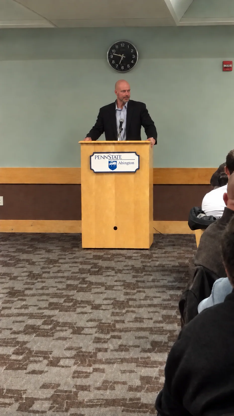 Bob File speaking at a podium in front of an audience.